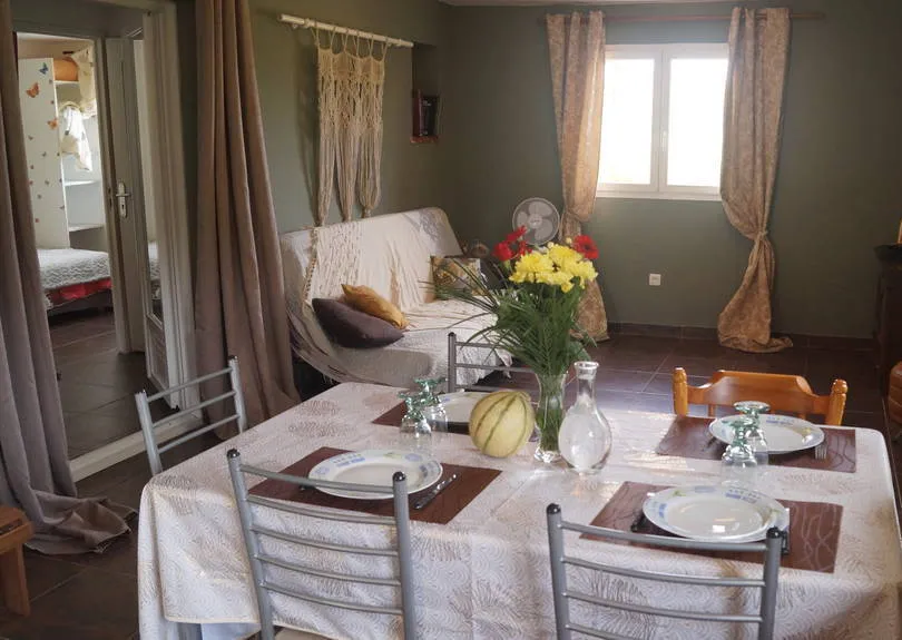 Séjour avec canapé, table à manger et accès à une chambre